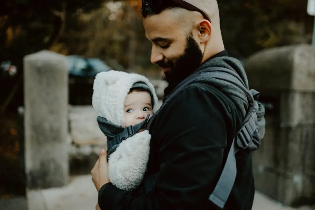 Image of a man holding his baby in the best baby carrier for dads